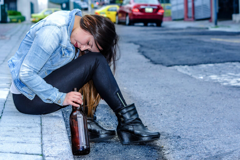 Beautiful,Young,Drunk,Woman,Sitting,In,A,Sidewalk,With,Bottle